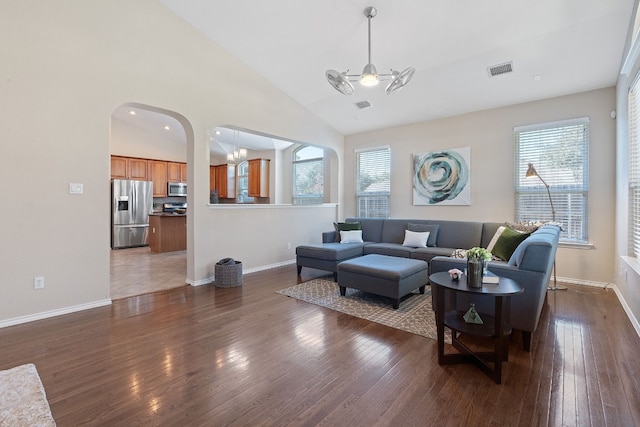 living room with ceiling fan, dark hardwood / wood-style flooring, and high vaulted ceiling