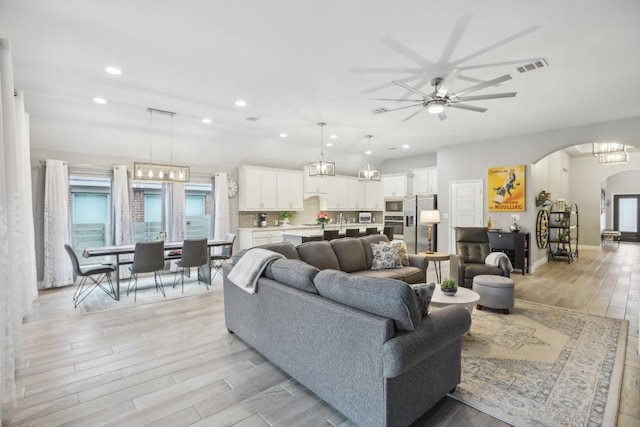 living room with ceiling fan and light hardwood / wood-style floors