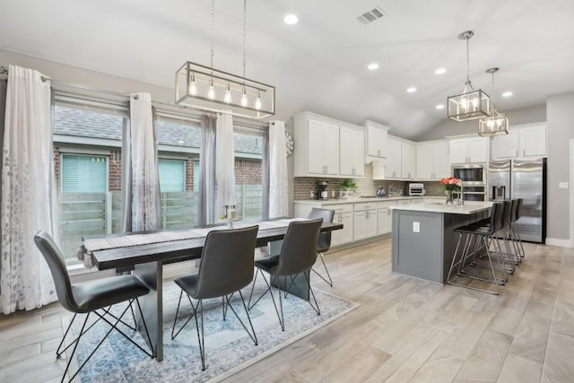 kitchen featuring stainless steel appliances, light countertops, visible vents, decorative backsplash, and white cabinetry