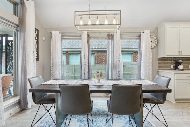 dining room with plenty of natural light and vaulted ceiling