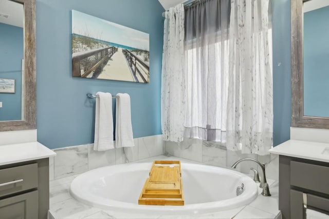 bathroom featuring vanity and tiled bath