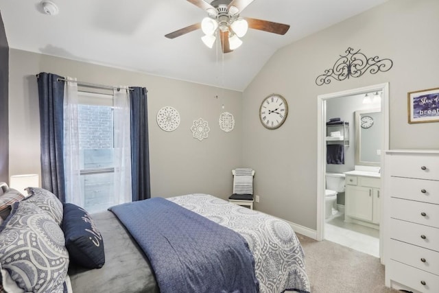 bedroom featuring ensuite bathroom, light carpet, a ceiling fan, baseboards, and vaulted ceiling