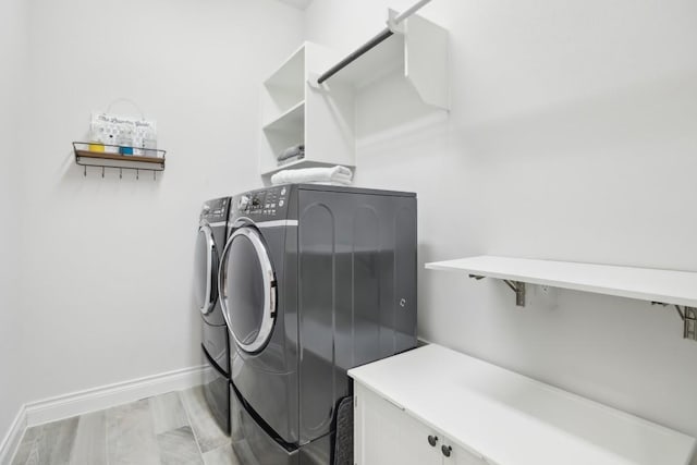 clothes washing area with laundry area, baseboards, and independent washer and dryer