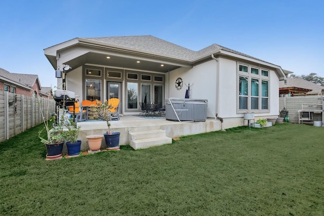 rear view of property with a patio, a lawn, a fenced backyard, and stucco siding