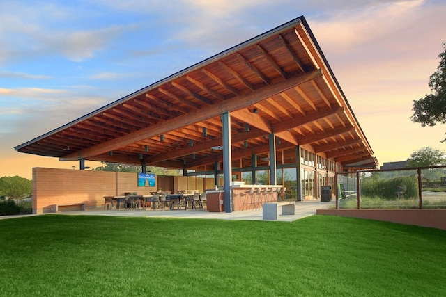 view of home's community featuring outdoor dry bar, a patio, and a lawn