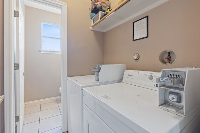 laundry room featuring washing machine and dryer and light tile patterned floors