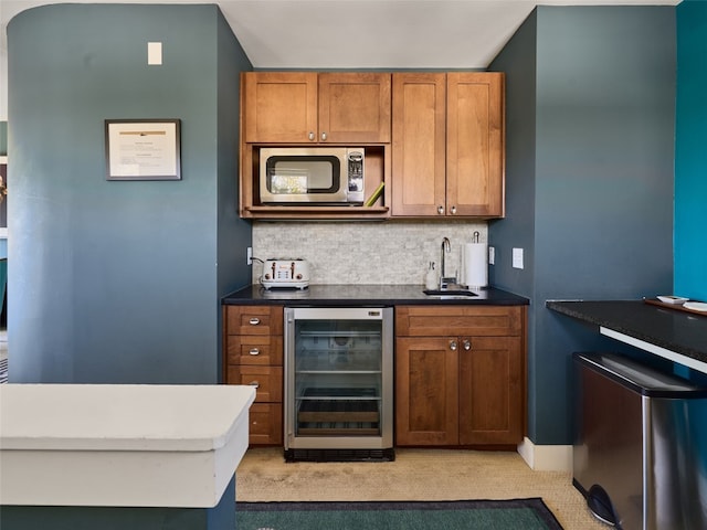 kitchen featuring sink, backsplash, and beverage cooler