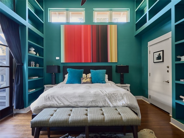 bedroom featuring wood-type flooring and a towering ceiling