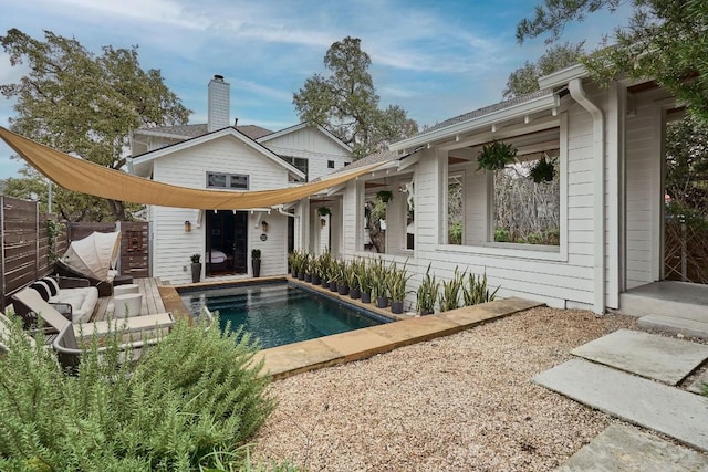 rear view of house featuring a fenced in pool and a patio