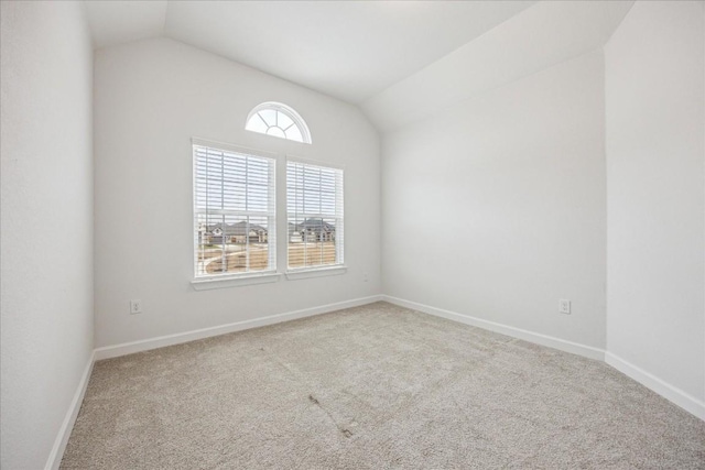 empty room with vaulted ceiling and carpet flooring