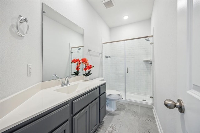 bathroom featuring vanity, walk in shower, and toilet