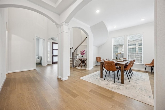 dining space with ornate columns and light hardwood / wood-style flooring