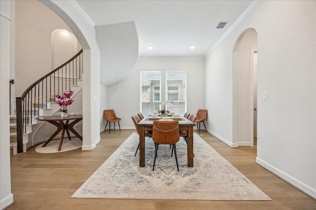 dining room featuring crown molding and light hardwood / wood-style flooring