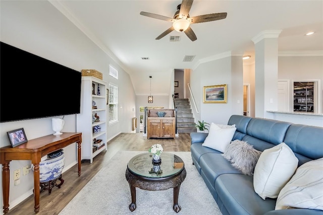 living room with hardwood / wood-style flooring, ornamental molding, ceiling fan, and ornate columns