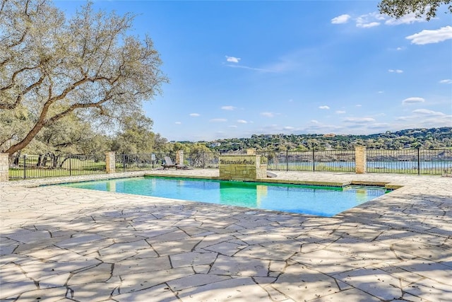 view of swimming pool with a water view and a patio area