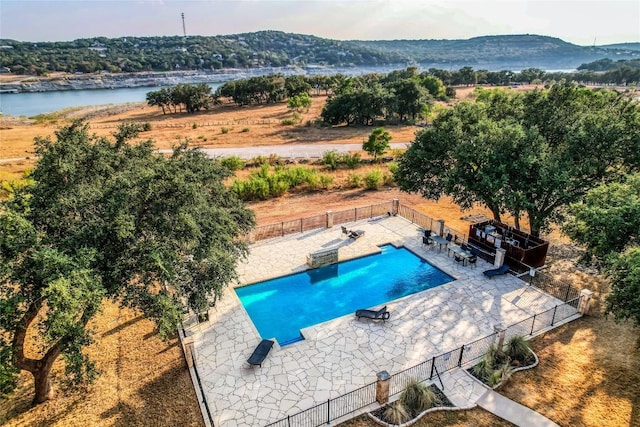 view of pool with a patio and a water and mountain view