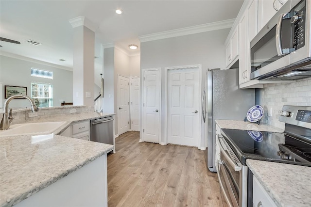 kitchen with white cabinetry, sink, stainless steel appliances, crown molding, and light hardwood / wood-style flooring