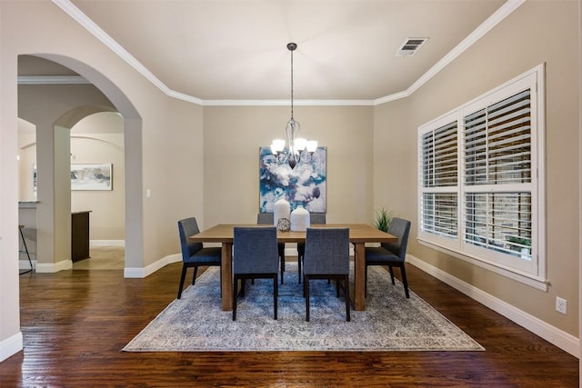 dining space with ornamental molding, a chandelier, and dark hardwood / wood-style flooring