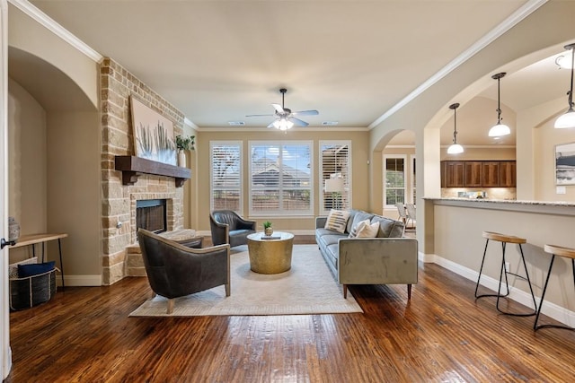 living room featuring ornamental molding, a fireplace, and dark hardwood / wood-style flooring