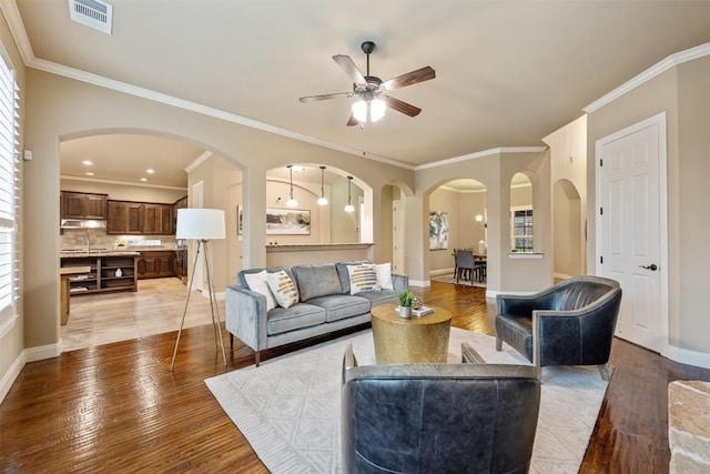 living room with crown molding and light hardwood / wood-style floors