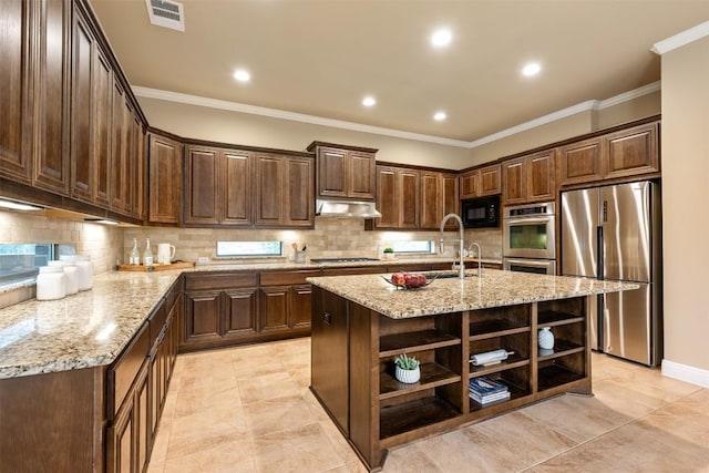 kitchen featuring stainless steel appliances, an island with sink, dark brown cabinets, and light stone counters