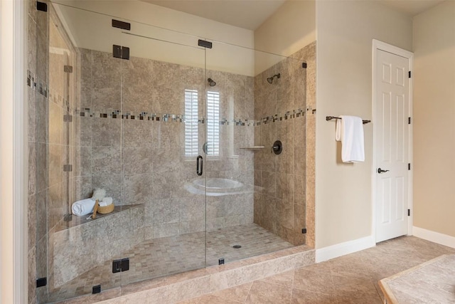 bathroom with a shower with door and tile patterned flooring