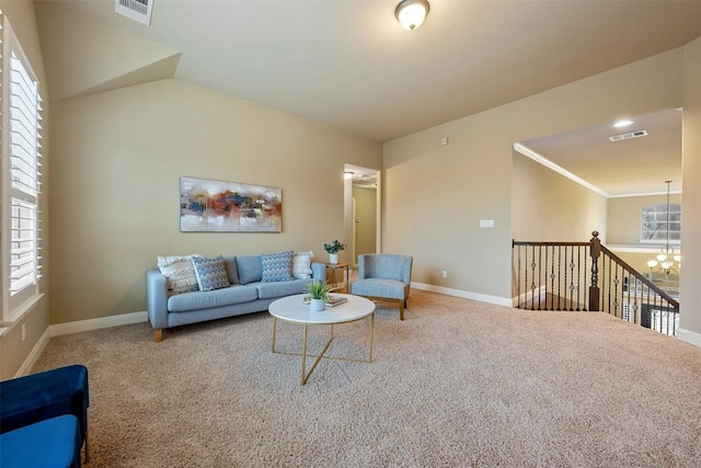 living room with ornamental molding, carpet floors, and a notable chandelier