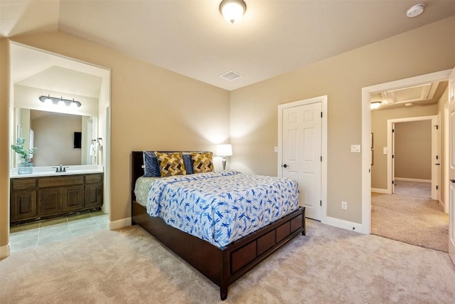 carpeted bedroom with ensuite bathroom and sink