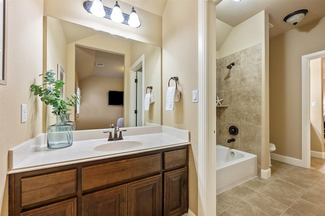 full bathroom with tile patterned floors, vanity, toilet, and tiled shower / bath combo