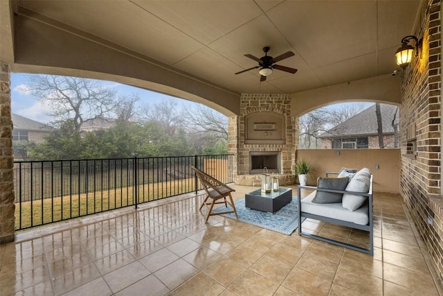 view of patio featuring ceiling fan and an outdoor living space with a fireplace