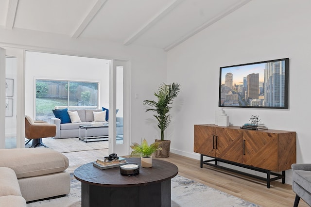 living room with hardwood / wood-style floors and vaulted ceiling with beams