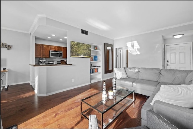 living room featuring ornamental molding, hardwood / wood-style floors, and built in features