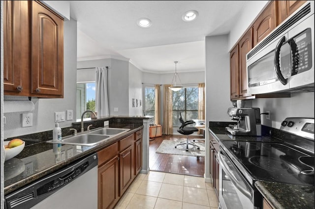 kitchen featuring sink, crown molding, appliances with stainless steel finishes, light tile patterned flooring, and decorative light fixtures