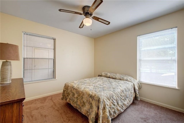 bedroom with ceiling fan, multiple windows, and light carpet