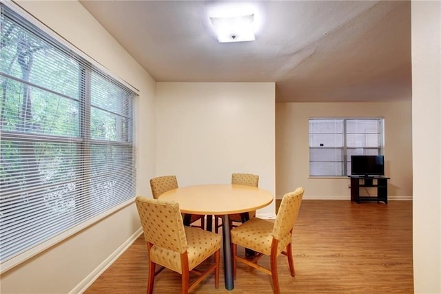 dining space with wood-type flooring