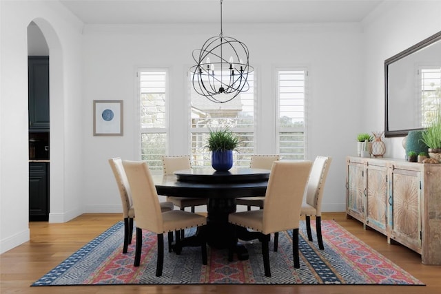 2520 Ionian Cv, Austin, TX 78730 - dining space with a chandelier, healthy amount of natural light, light wood finished floors, arched walkways, and crown molding