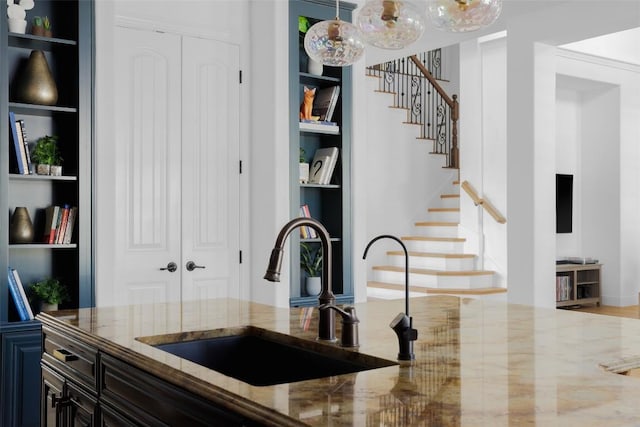 2520 Ionian Cv, Austin, TX 78730 - kitchen with a sink, built in shelves, light stone counters, and decorative light fixtures