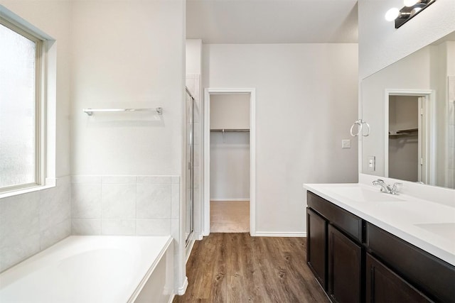 bathroom with vanity, hardwood / wood-style floors, and plus walk in shower