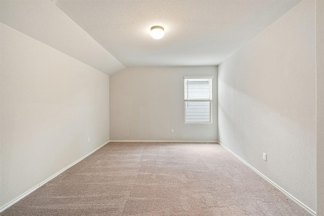 bonus room with light carpet, vaulted ceiling, and a textured ceiling