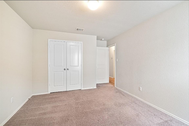 unfurnished bedroom featuring a closet and carpet flooring