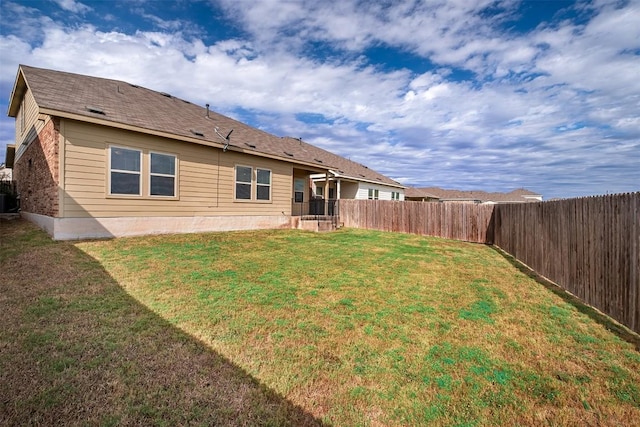 back of house with central AC unit and a lawn