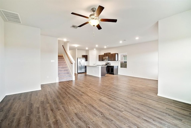 unfurnished living room featuring dark hardwood / wood-style floors and ceiling fan