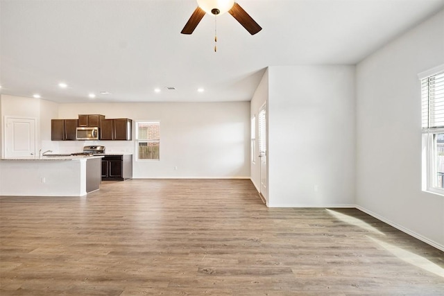 unfurnished living room with ceiling fan, light hardwood / wood-style floors, and a wealth of natural light