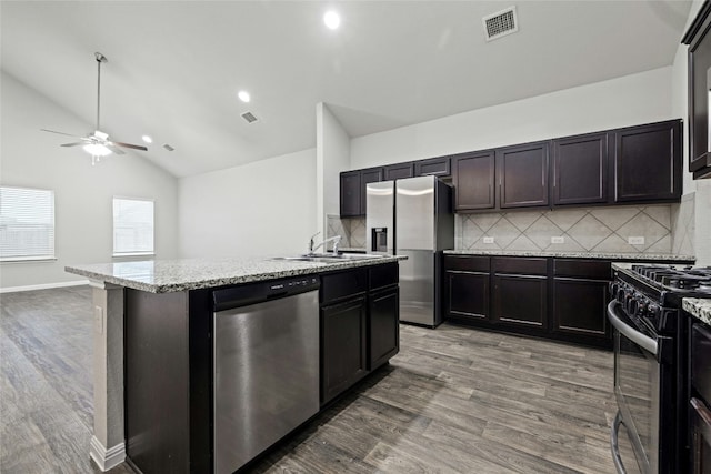 kitchen featuring hardwood / wood-style floors, appliances with stainless steel finishes, sink, and a center island with sink