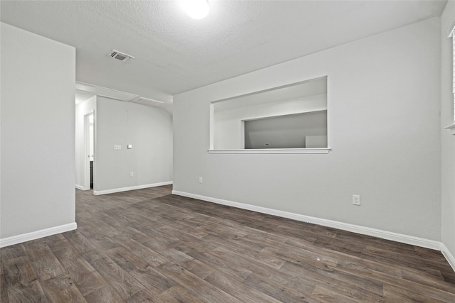 empty room featuring dark hardwood / wood-style flooring and a textured ceiling