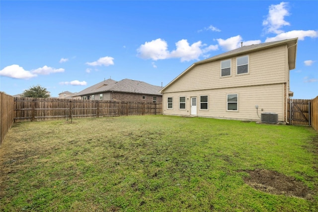 rear view of house featuring cooling unit and a lawn