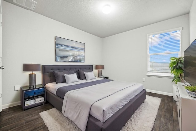 bedroom with dark wood-type flooring and a textured ceiling