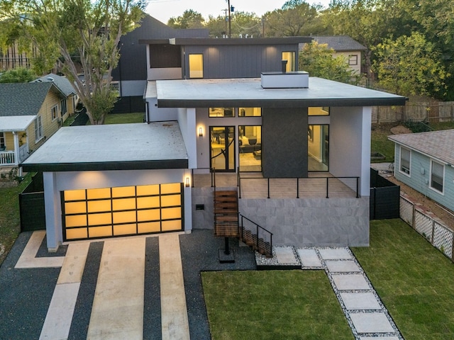 contemporary house featuring a garage and a front lawn