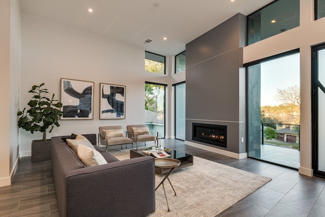 living room featuring a large fireplace and a high ceiling