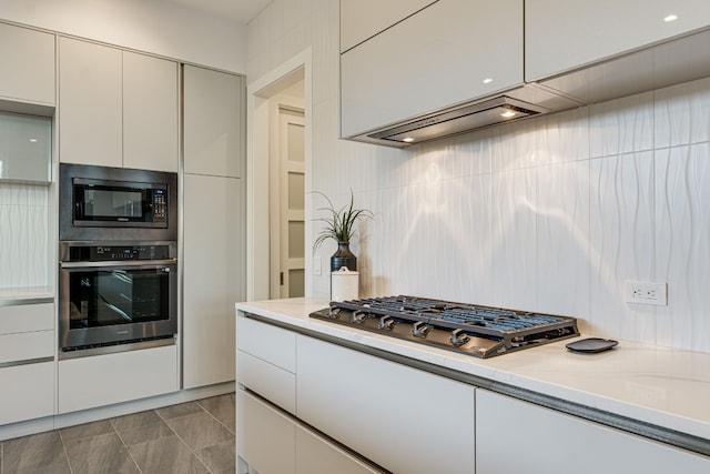 kitchen featuring light tile patterned floors, stainless steel appliances, and white cabinets